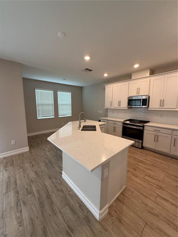 The exterior of a two-story townhouse features a balcony, sliding glass doors, and a patio — 4599 ALMADA LANE, WESLEY CHAPEL, FL
