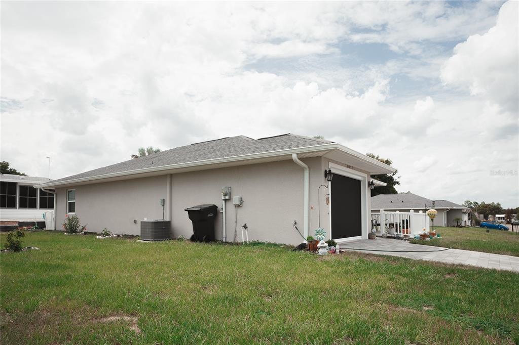 A side view of a single-story house with a garage and a paved driveway — 7077 TAMARIND WAY, LAKE WALES, FL