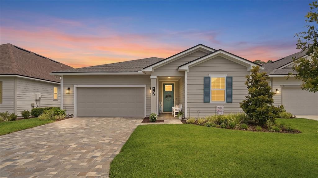 A single-story house with light gray siding, a paved driveway, and a teal front door — 40 MOANA COURT S, PALM COAST, FL