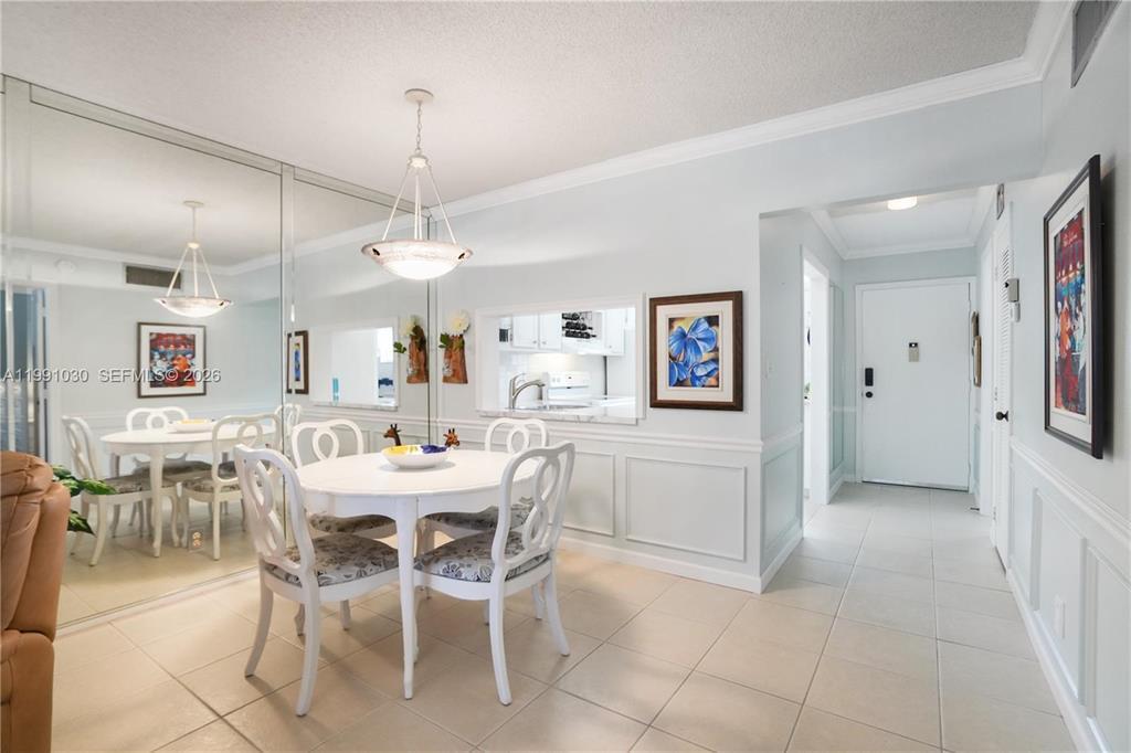 A dining area with a round table, white chairs, and a mirrored wall — 1501 S Ocean Boulevard # 214, Pompano Beach FL 33062, POMPANO BEACH, FL