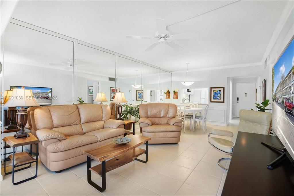 A living room with beige leather furniture, a wooden coffee table, and a mirrored wall — 1501 S Ocean Boulevard # 214, Pompano Beach FL 33062, POMPANO BEACH, FL