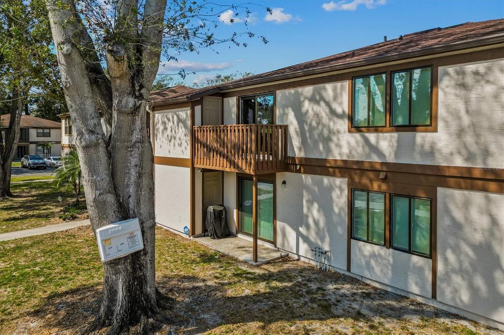 An exterior view of a two-story apartment building with a wooden balcony and patio — 4903 LAKE RIDGE ROAD UNIT GE, ORLANDO, FL