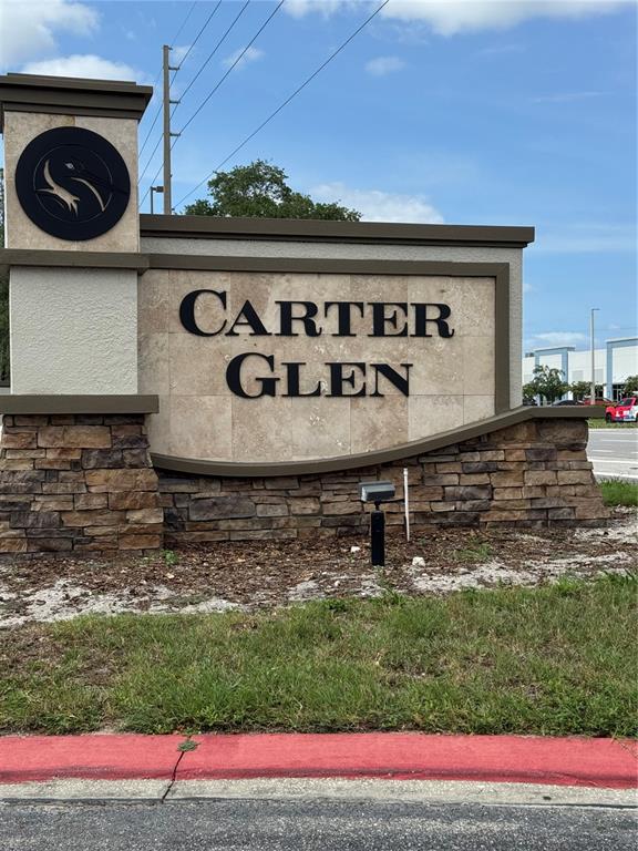 A stone and stucco monument sign displays the name Carter Glen against a blue sky — 6404 S GOLDENROD ROAD UNIT 2A, ORLANDO, FL