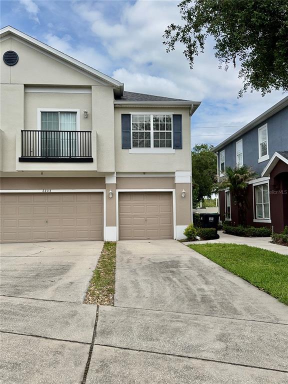 A two-story townhouse features two garage doors, a balcony, and a concrete driveway — 6404 S GOLDENROD ROAD UNIT 2A, ORLANDO, FL
