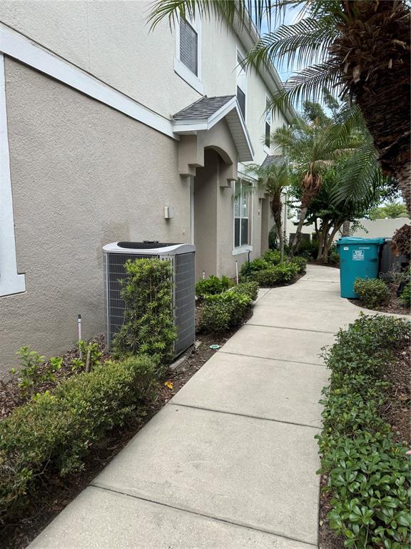 A concrete walkway leads past a residential building exterior with an air conditioning unit — 6404 S GOLDENROD ROAD UNIT 2A, ORLANDO, FL