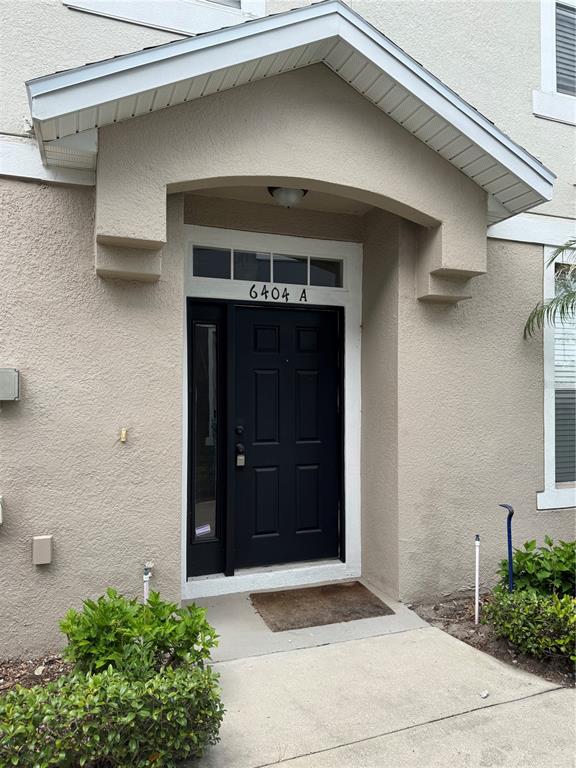 The exterior of a residential building features a dark front door under a covered entryway — 6404 S GOLDENROD ROAD UNIT 2A, ORLANDO, FL