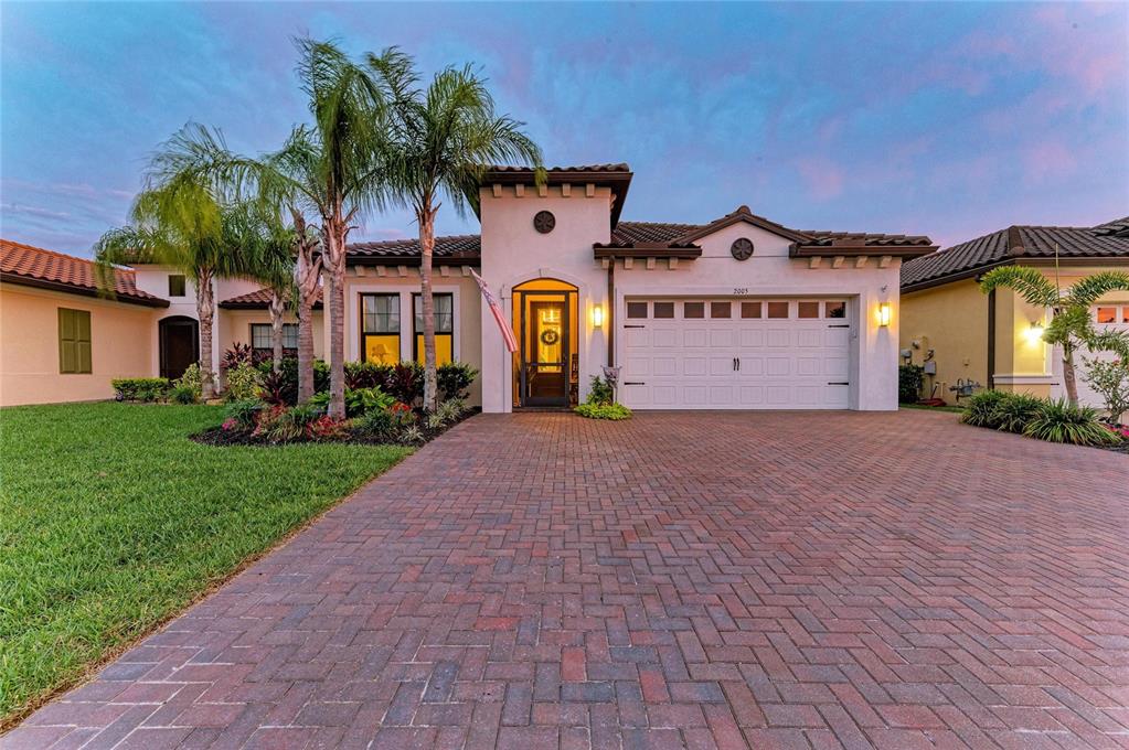 A single-story stucco house with a brick paver driveway and a two-car garage — 2005 6TH ST E, PALMETTO, FL
