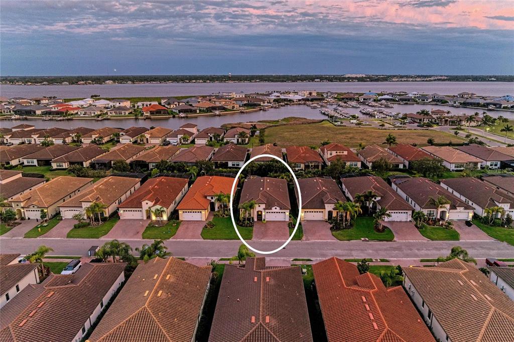 An aerial view shows a single-family home circled in a residential neighborhood near a bay — 2005 6TH ST E, PALMETTO, FL