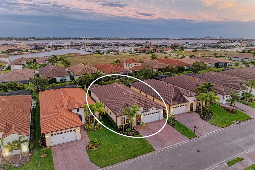 An aerial view shows a single-story suburban house with a tiled roof and attached garage — 2005 6TH ST E, PALMETTO, FL