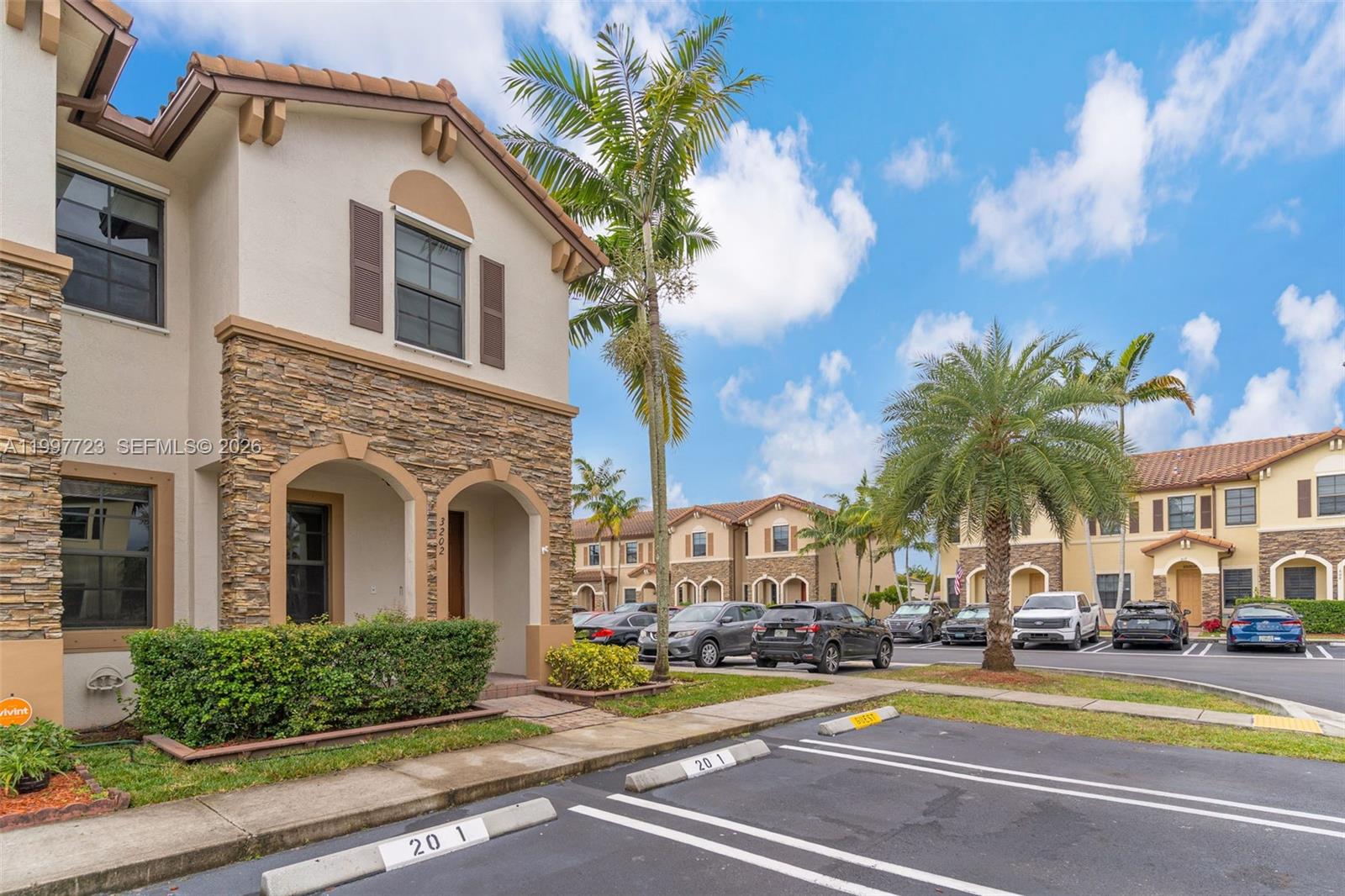 A two-story residential building with stone veneer and stucco siding features a palm tree exterior — 3202 SE 6th St, Homestead FL 33033, HOMESTEAD, FL
