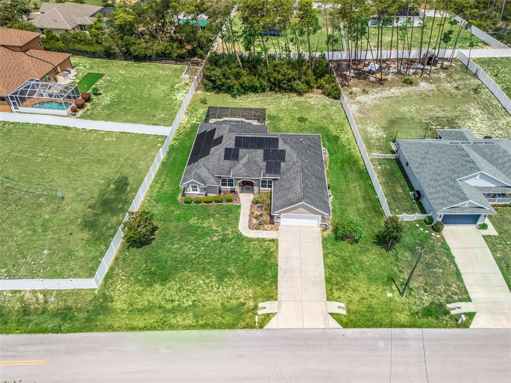 An aerial view shows a single-story house with solar panels, a pool enclosure, and driveway — 4443 SW 108TH PLACE, OCALA, FL