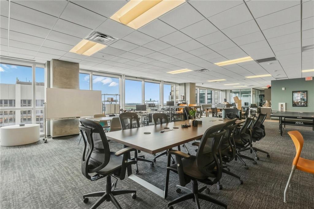 A modern office conference room features a long table, ergonomic chairs, and floor-to-ceiling windows — 189 S ORANGE AVENUE UNIT 1950S, ORLANDO, FL