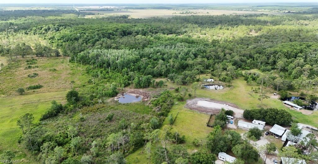 An aerial view shows a rural property with multiple small ponds, trees, and several structures — 1375 W ASH ROAD, LABELLE, FL