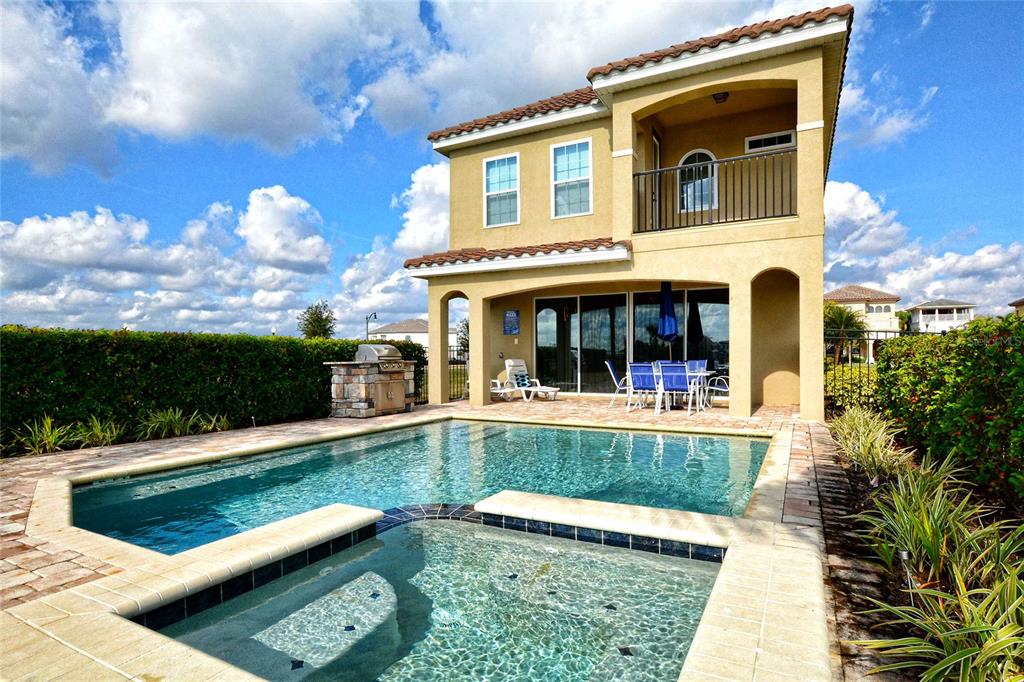 A two-story house with a backyard swimming pool, spa, and a covered patio area — 7824 LOXAHATCHEE COURT, REUNION, FL
