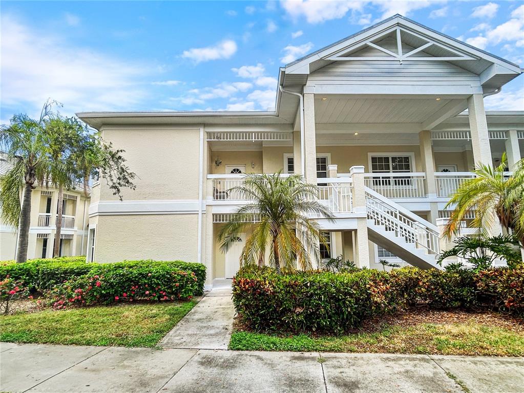 A two-story apartment building with a staircase leading to an upper-level balcony — 3701 54TH DRIVE W UNIT 104, BRADENTON, FL