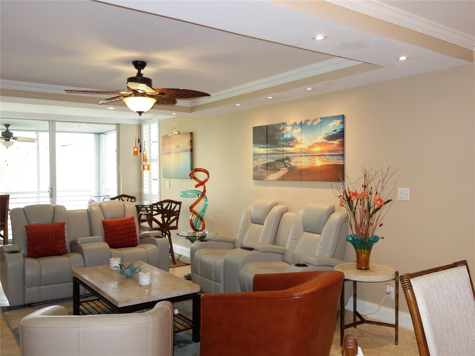 A living room features light-colored leather recliners, a stone coffee table, and coastal wall art — 625 Oaks Drive # 302, Pompano Beach FL 33069, POMPANO BEACH, FL