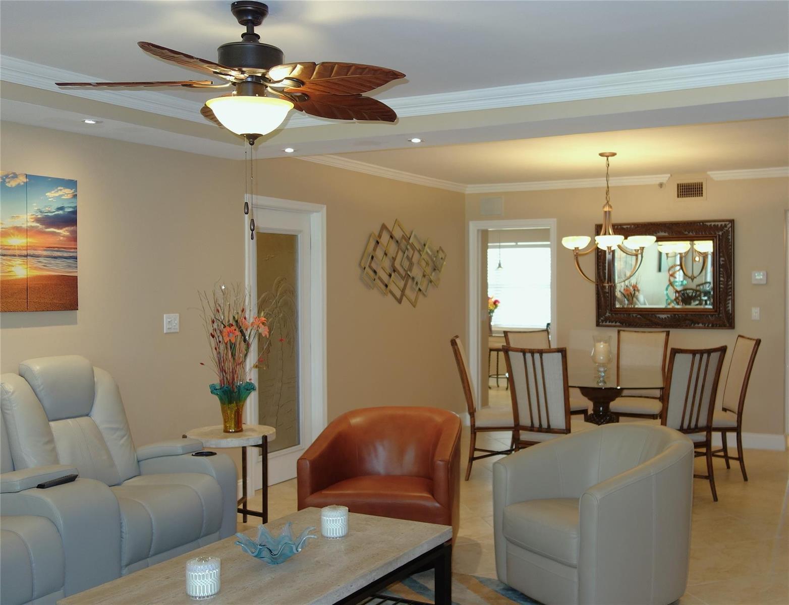 A living room and dining area featuring a ceiling fan, leather chairs, and neutral walls — 625 Oaks Drive # 302, Pompano Beach FL 33069, POMPANO BEACH, FL