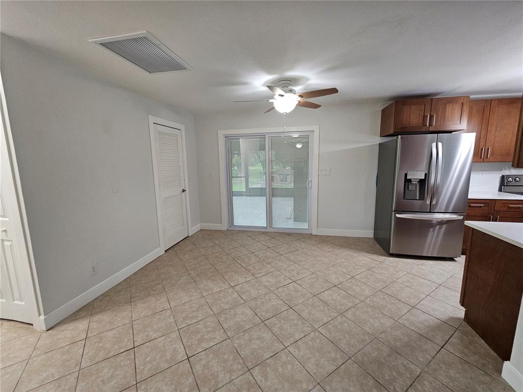 A kitchen dining area with tile flooring, a ceiling fan, and sliding glass patio doors — 16225 BELLAMY BROTHERS BOULEVARD, DADE CITY, FL