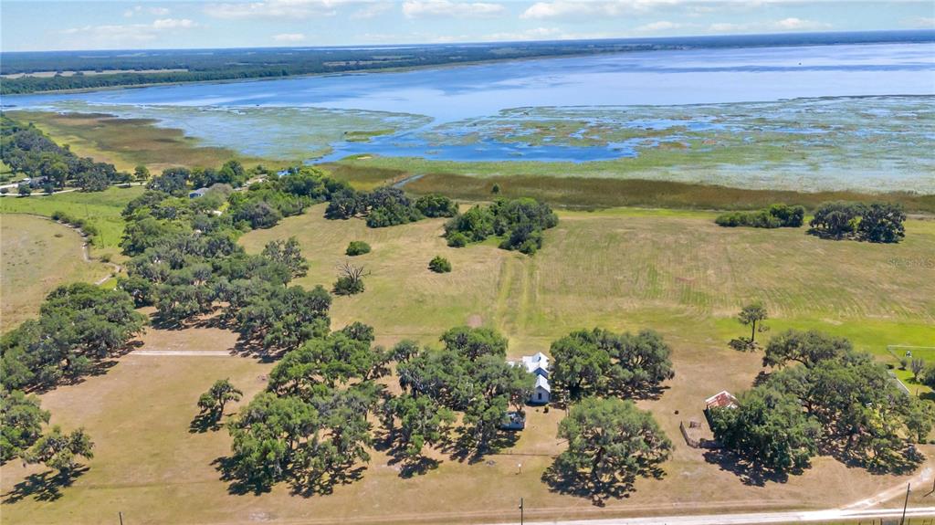 An aerial view shows a rural property with a house, scattered trees, and a large lake — 3650 LAKE TOHOPEKALIGA ROAD, ST CLOUD, FL
