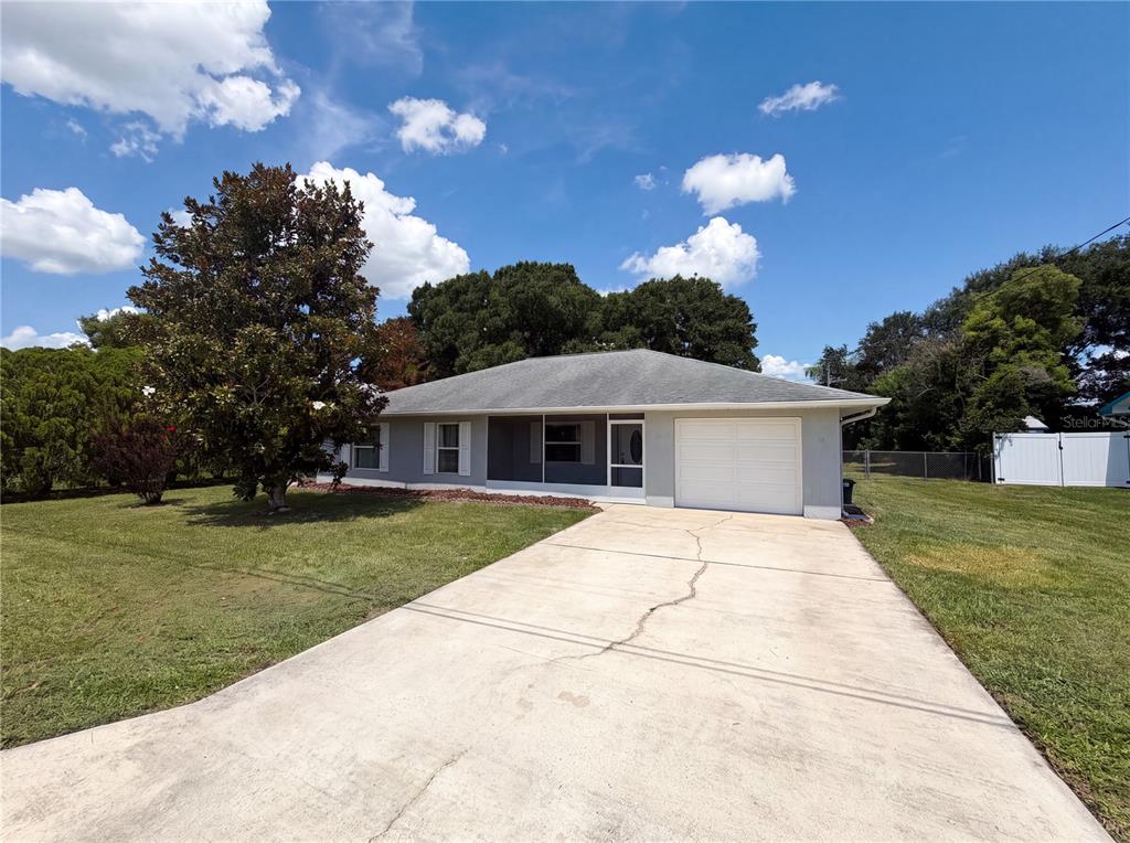 A single-story house with a gray exterior, a white garage door, and a concrete driveway — 4846 MAC DONALD STREET, LAKE WALES, FL