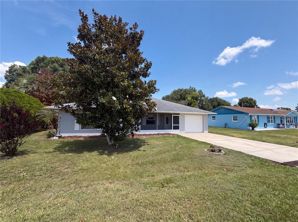 A single-story house with a gray exterior, a large tree, and a concrete driveway — 4846 MAC DONALD STREET, LAKE WALES, FL