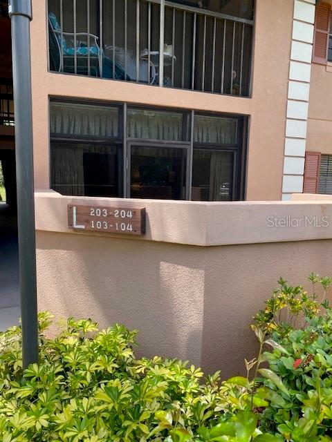 An exterior view of a multi-story building with a sign indicating units 103-204 — 1515 FORREST NELSON BOULEVARD UNIT L104, PORT CHARLOTTE, FL