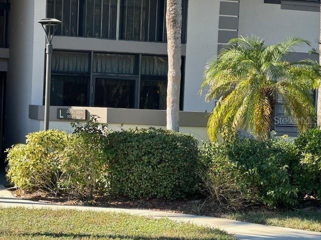 A palm tree stands in front of a multi-story building with a unit number sign — 1515 FORREST NELSON BOULEVARD UNIT L104, PORT CHARLOTTE, FL