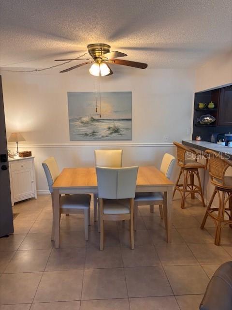 A dining area with a wooden table, four chairs, a ceiling fan, and bar seating — 1515 FORREST NELSON BOULEVARD UNIT L104, PORT CHARLOTTE, FL