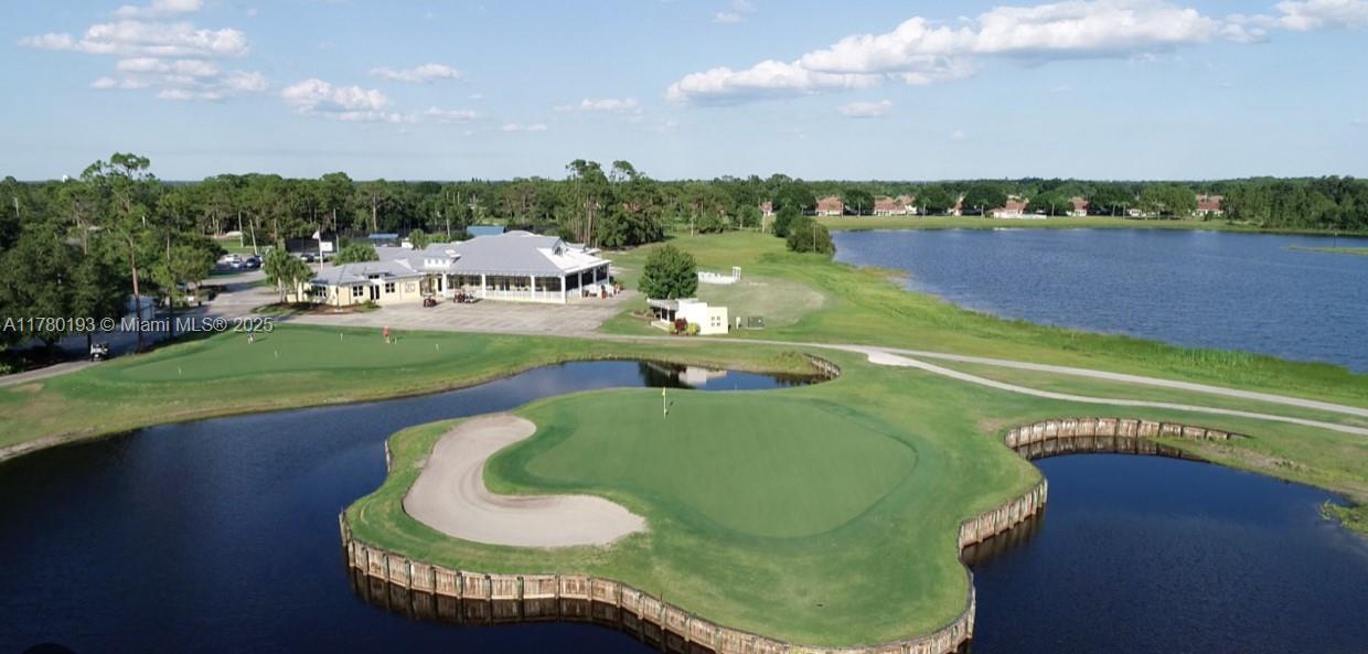 An aerial view shows a golf course green surrounded by water near a clubhouse building — 7004 Mona Avenue, Sebring FL 33872, SEBRING, FL