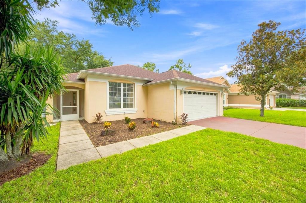 A single-story house with a beige exterior, a two-car garage, and a front walkway — 2393 PAULETTE DRIVE, HAINES CITY, FL