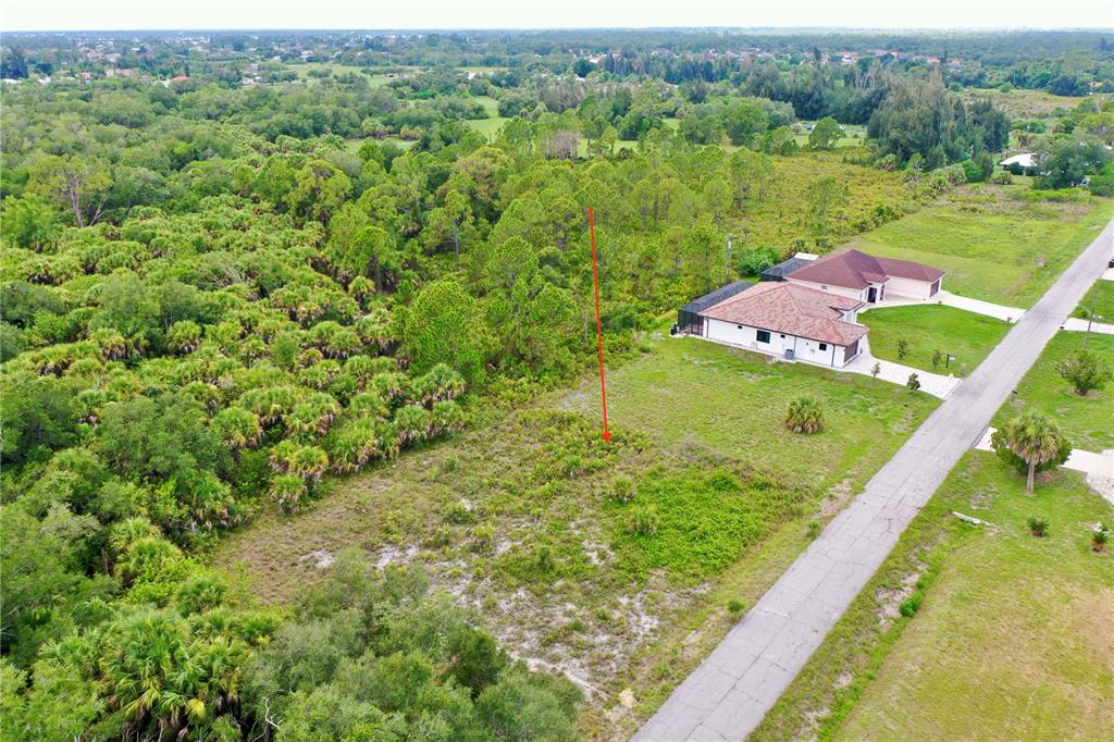 An aerial view shows a vacant, partially wooded residential lot next to a suburban house — DURANGO AVENUE, NORTH PORT, FL