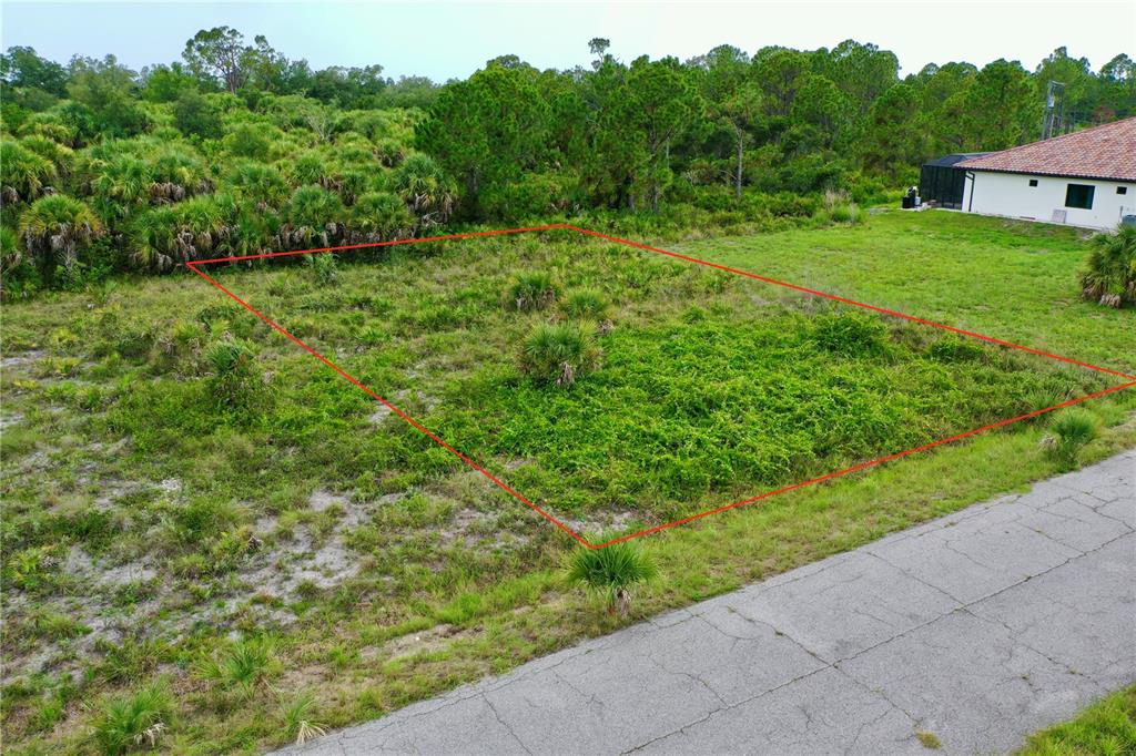 An aerial view shows a rectangular vacant lot outlined in red next to a house — DURANGO AVENUE, NORTH PORT, FL