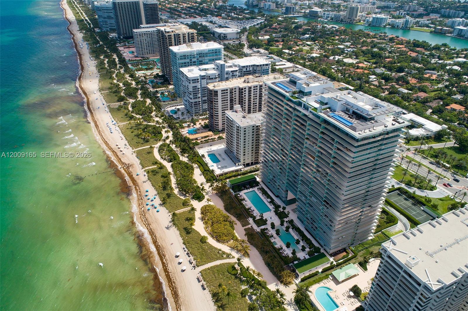 An aerial view shows high-rise residential buildings along a sandy beach and the ocean — 10201 Collins Ave # 503, Bal Harbour FL 33154, BAL HARBOUR, FL
