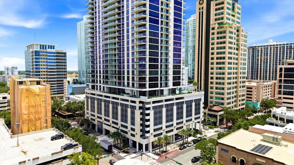 An aerial view shows a tall modern residential tower surrounded by other city buildings — 275 1ST AVENUE S UNIT 3308, ST PETERSBURG, FL