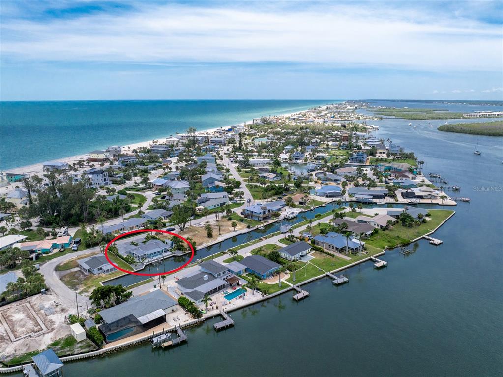 An aerial view shows a coastal neighborhood with a red circle highlighting a waterfront house — 1265 HOLIDAY DRIVE, ENGLEWOOD, FL