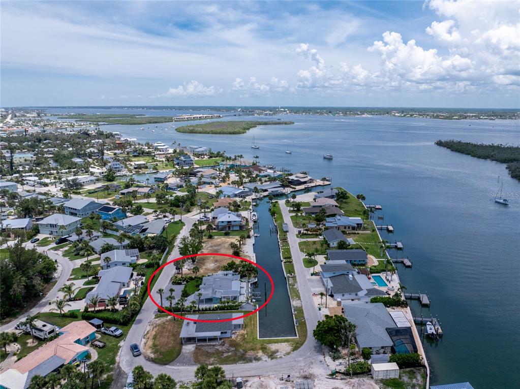 An aerial view shows a waterfront house with a private dock along a canal — 1265 HOLIDAY DRIVE, ENGLEWOOD, FL