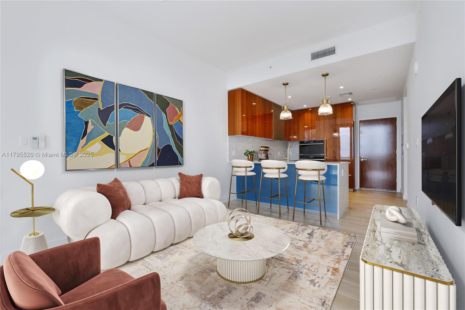 A modern living room features a white tufted sofa, marble coffee table, and blue kitchen — 2678 Tigertail Ave # 1205, Miami FL 33133, MIAMI, FL
