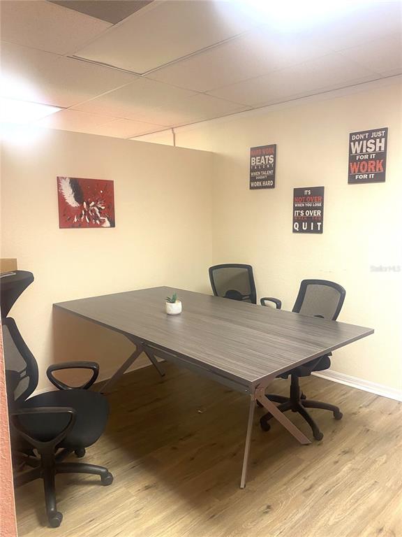 An office space features a wooden desk, three rolling chairs, and motivational wall art — 7448 S US HIGHWAY 1, PORT ST LUCIE, FL
