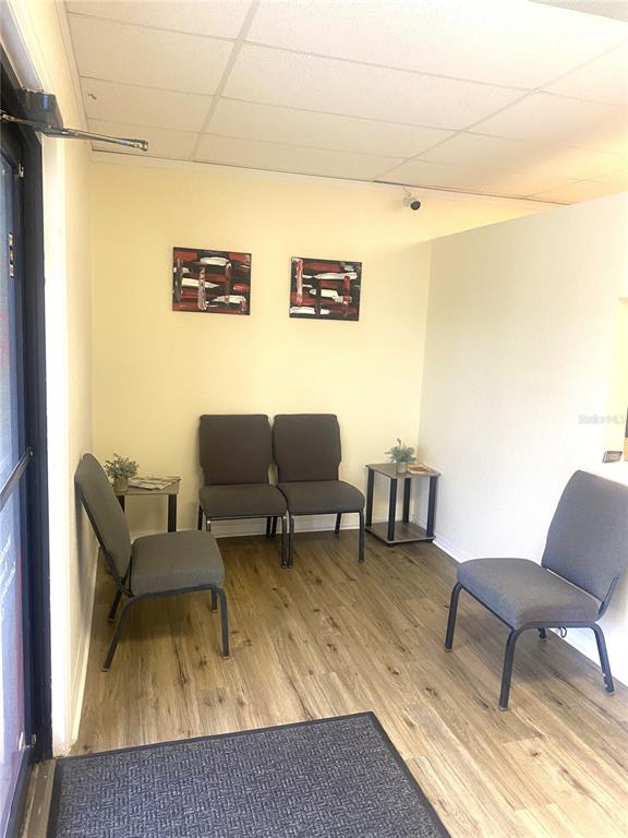 A waiting area features four gray chairs, two small side tables, and two wall-mounted paintings — 7448 S US HIGHWAY 1, PORT ST LUCIE, FL