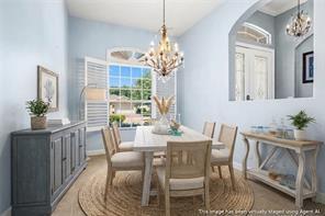 A dining room with light blue walls, a wooden table, and a crystal chandelier — VERO BEACH, FL