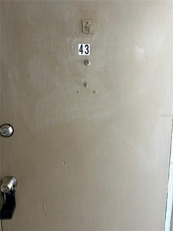 A beige apartment door features the number 43, a peephole, and two door locks — 1229 KENNEDY ROAD UNIT 43, DAYTONA BEACH, FL