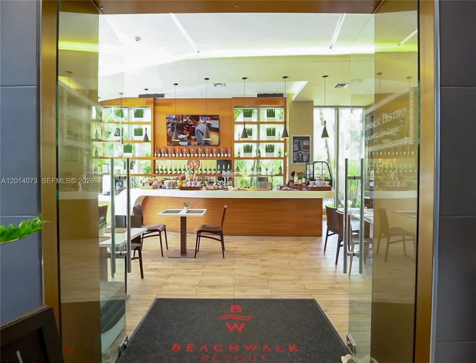 A view through a glass doorway into a resort bistro with a wooden bar — 2602 E Hallandale Beach Blvd # R806, Hallandale Beach FL 33009, HALLANDALE BEACH, FL