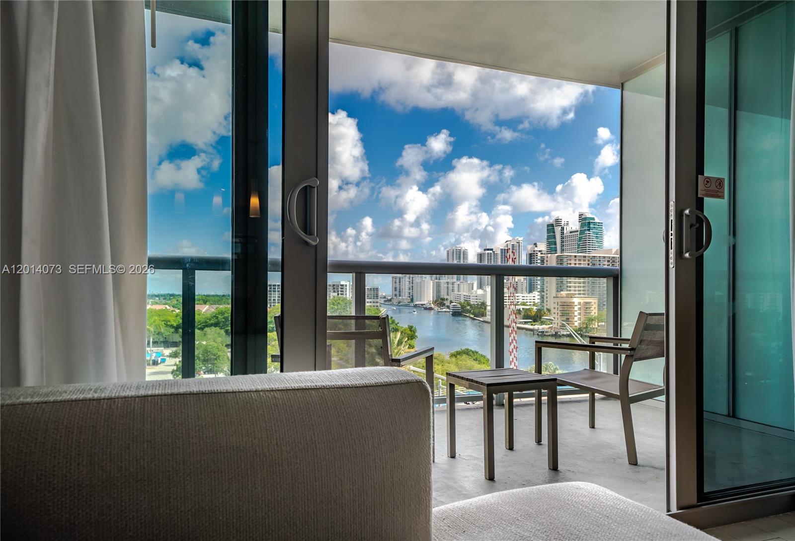A balcony with chairs and a table overlooks a river and city skyline — 2602 E Hallandale Beach Blvd # R806, Hallandale Beach FL 33009, HALLANDALE BEACH, FL
