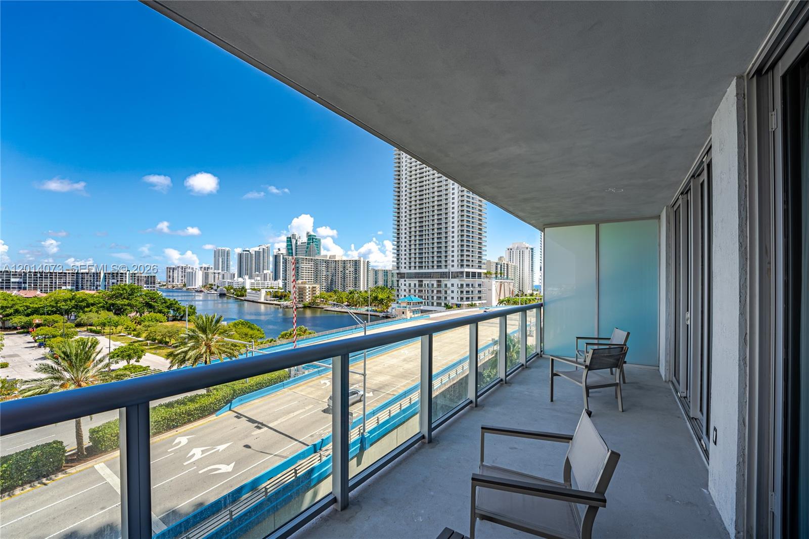 A balcony with chairs overlooks a bridge, a waterway, and a city skyline — 2602 E Hallandale Beach Blvd # R806, Hallandale Beach FL 33009, HALLANDALE BEACH, FL