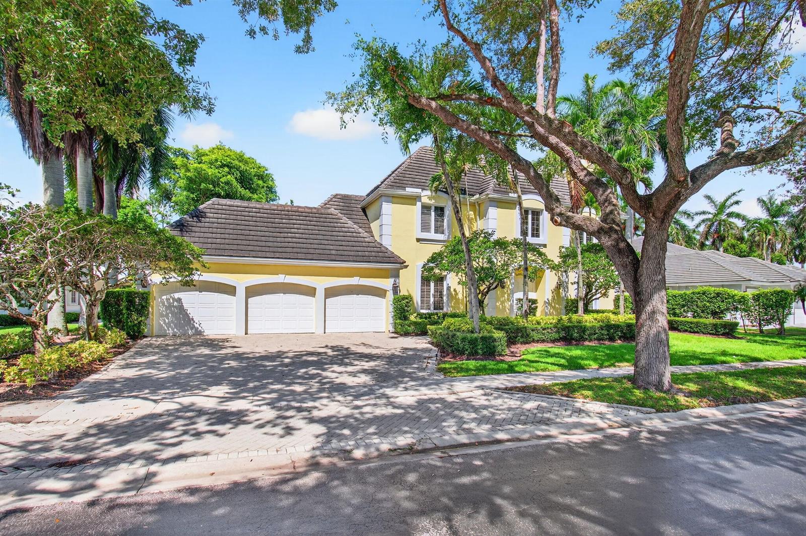 A yellow two-story house with a three-car garage and a paved driveway — 6167 NW 23rd Way, Boca Raton FL 33496, BOCA RATON, FL
