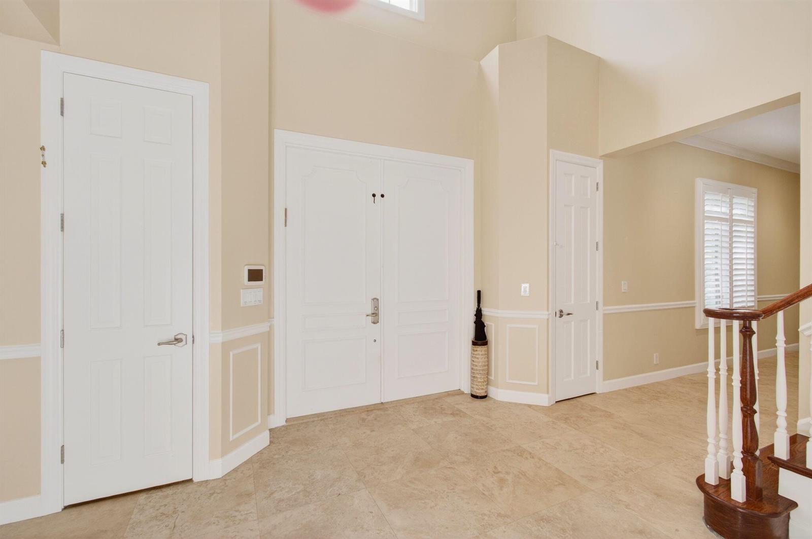 A foyer with tile flooring, white doors, and a staircase leading to an upper level — 6167 NW 23rd Way, Boca Raton FL 33496, BOCA RATON, FL
