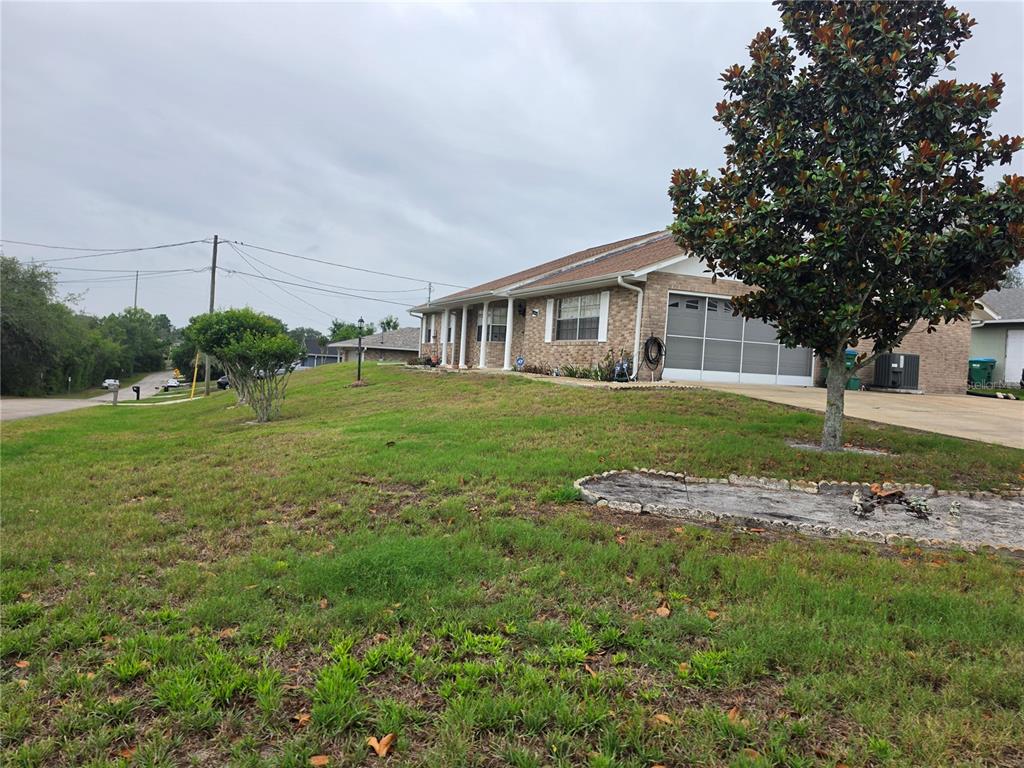 A brick house with a garage and a large tree in the front yard — 1732 TOPAZ TERRACE, DELTONA, FL