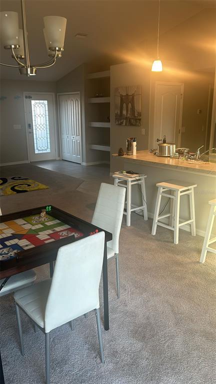 A dining area with a game table and a kitchen island with bar stools — 8316 NEVADA STREET, SPRING HILL, FL