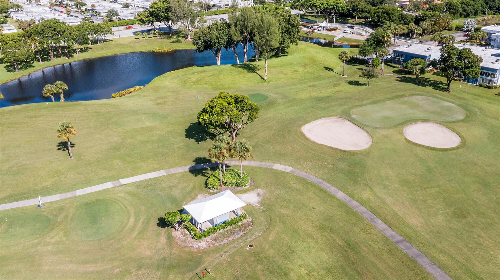 An aerial view shows a golf course with a small shelter, sand traps, and pond — 344 Piedmont, Delray Beach FL 33484, DELRAY BEACH, FL