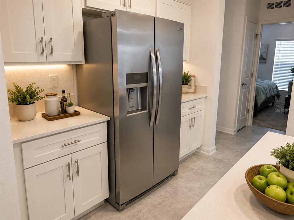 A kitchen features white cabinets, stainless steel appliances, and a bowl of green apples — 5782 LE MARIN WAY, KISSIMMEE, FL